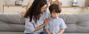 photo of a woman comforting a young child on a couch
