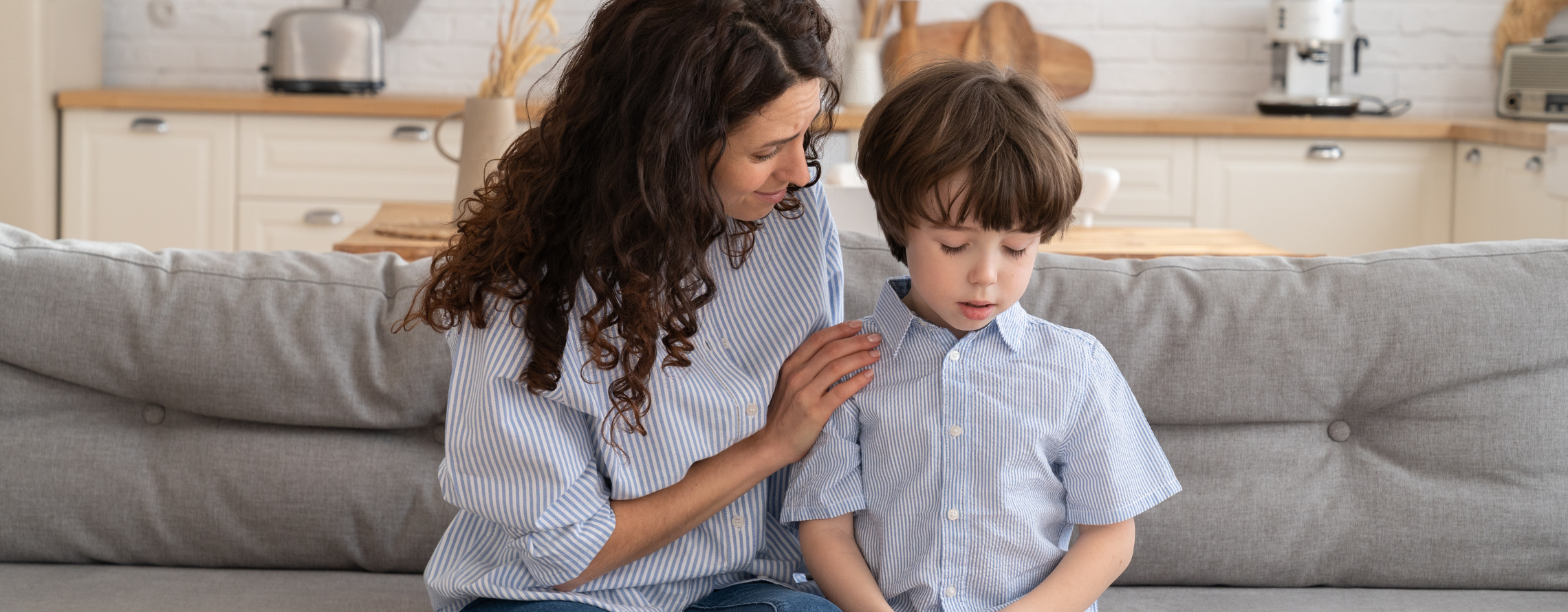 photo of a woman comforting a young child on a couch